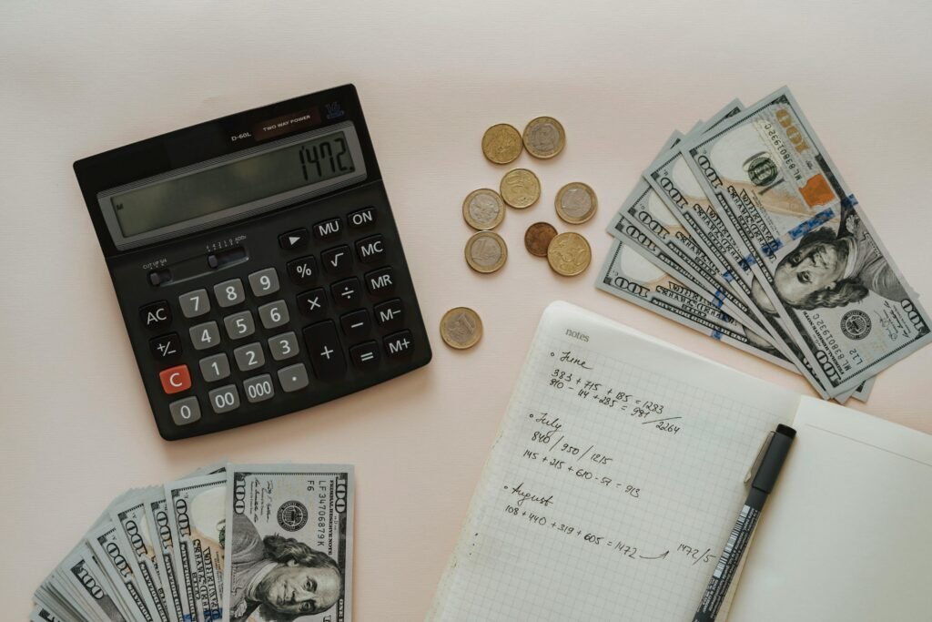 Calculator, cash and notebook, doing the math on passive income ideas