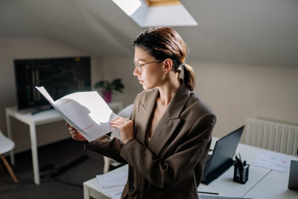 Woman reading financial documents at a desk while comparing a money market account