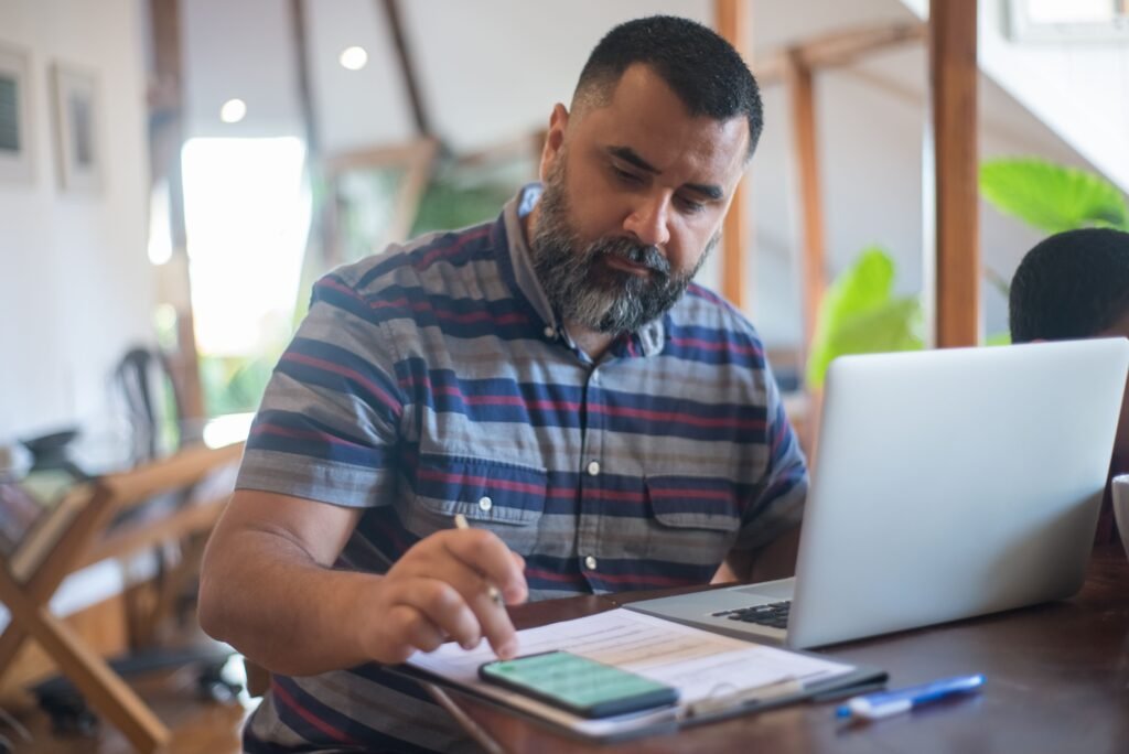 Man at a laptop with notes, working out the numbers on a cash out refinance
