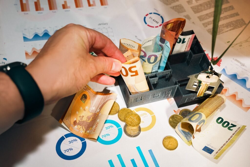 Hand sorting euro banknotes and coins over charts, planning a cd ladder