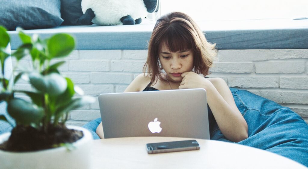 Freelancer at a laptop with a worried look, thinking about freelance invoicing and late payments