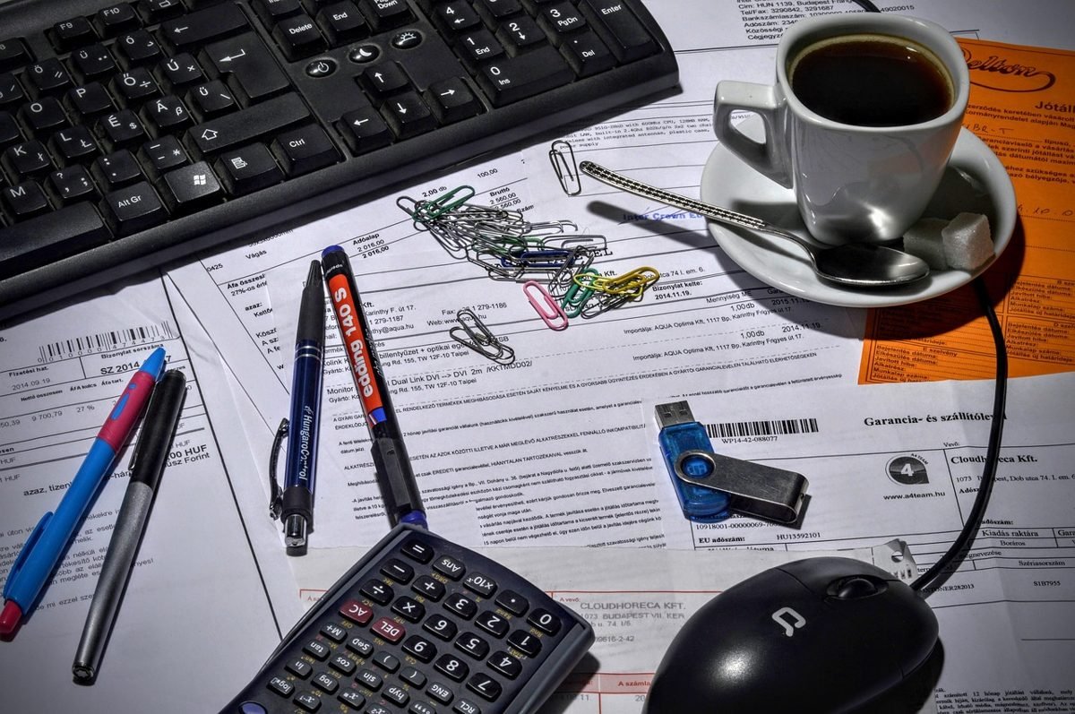Desk with receipts, keyboard and calculator for tracking freelance expenses