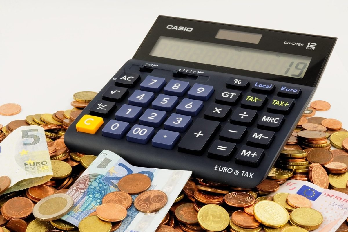 Calculator and coins used to compare quotes and lower car insurance rates