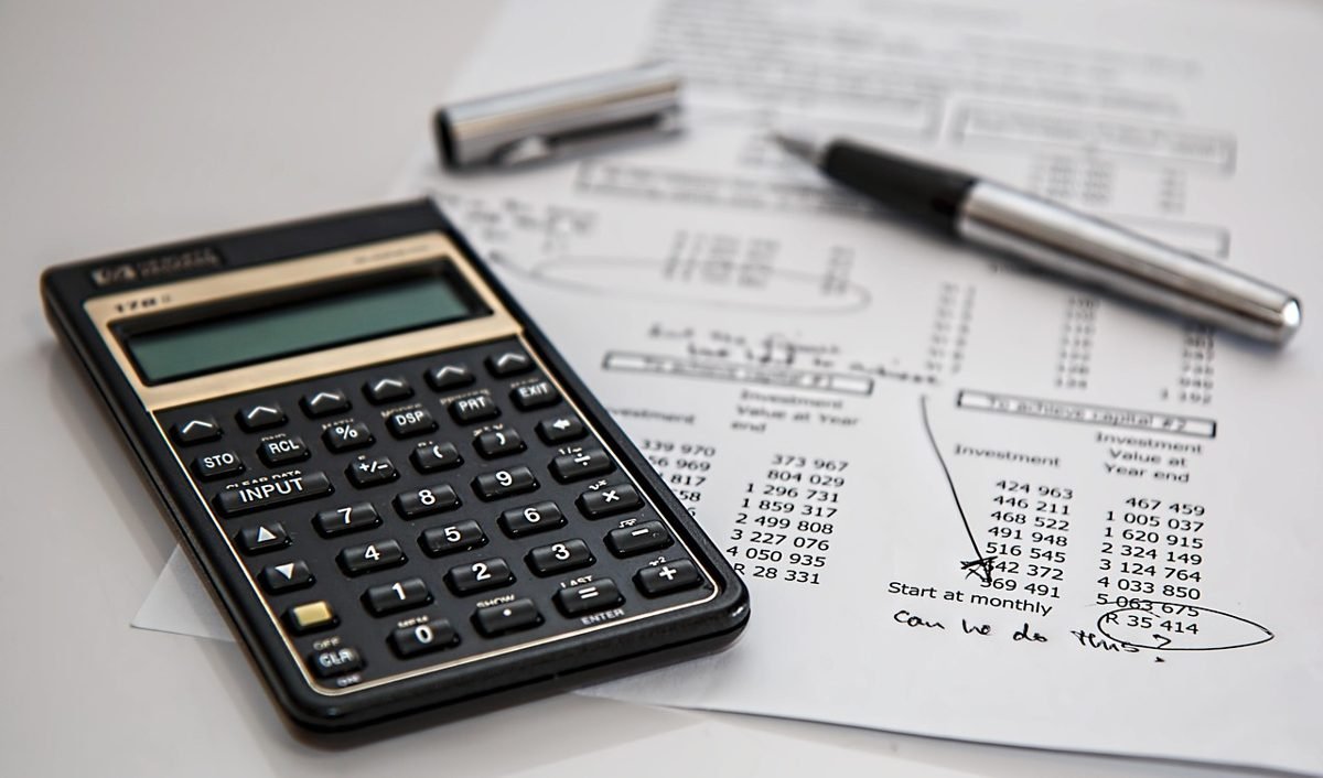 Calculator and financial paperwork used to compare rent vs buy costs