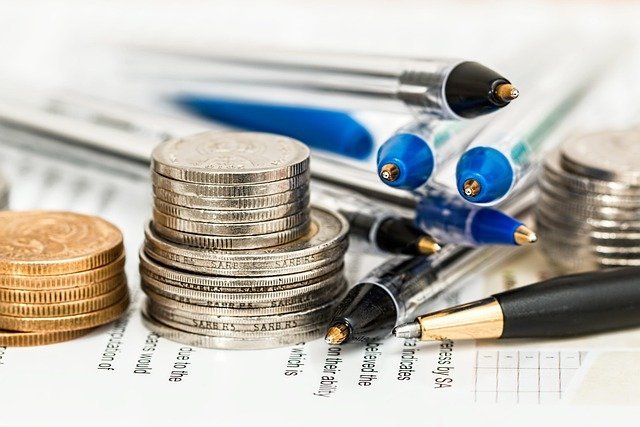 Coins and pens on paper, the paperwork of opening a money market account