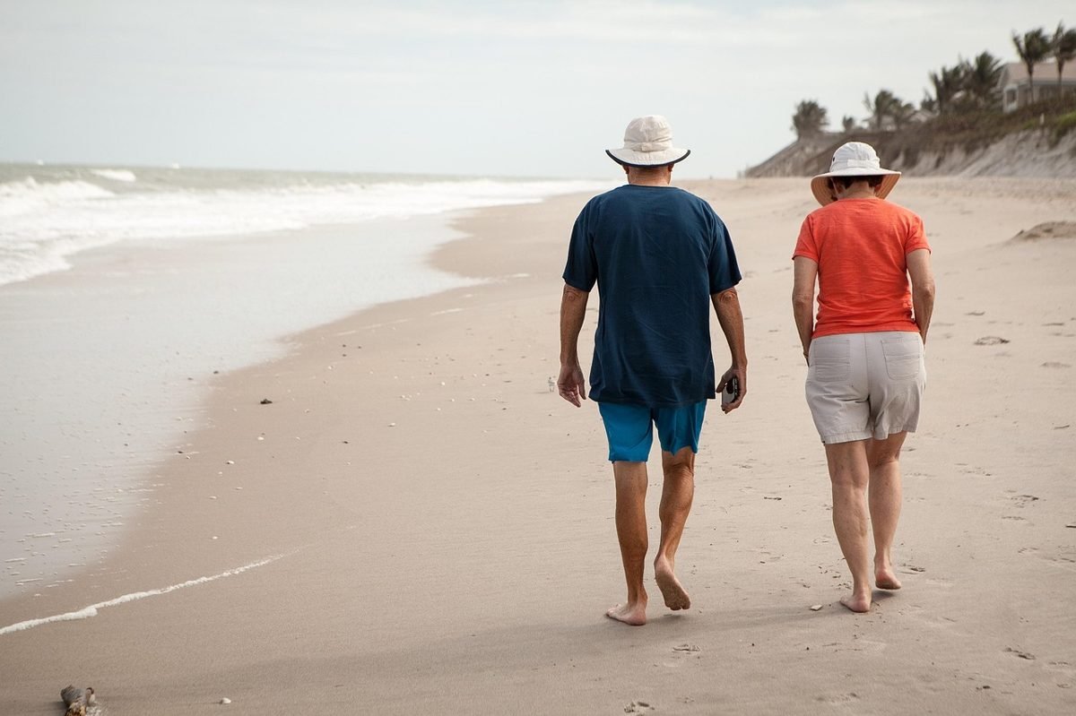 Couple on a beach after planning how much to save for retirement