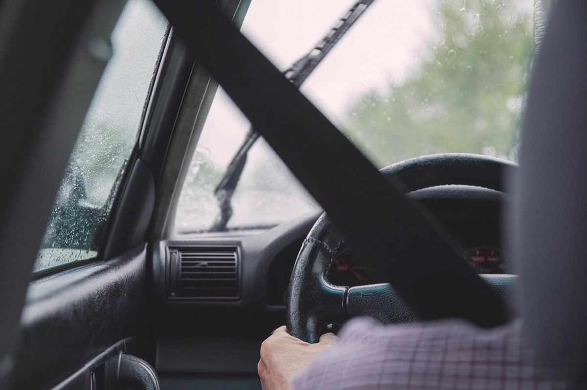 Driver with hands on the steering wheel, a safe habit that helps lower car insurance rates