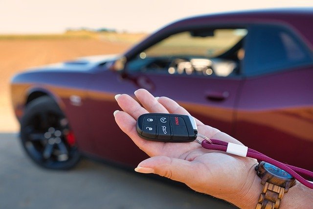 Hand holding a car key, the moment at lease end when you return or buy in a lease vs buy a car choice