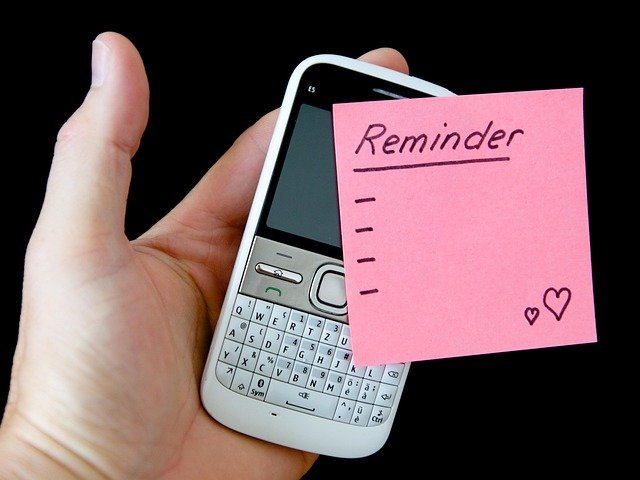 Hand holding a phone and note, tracking payments to cut credit card interest