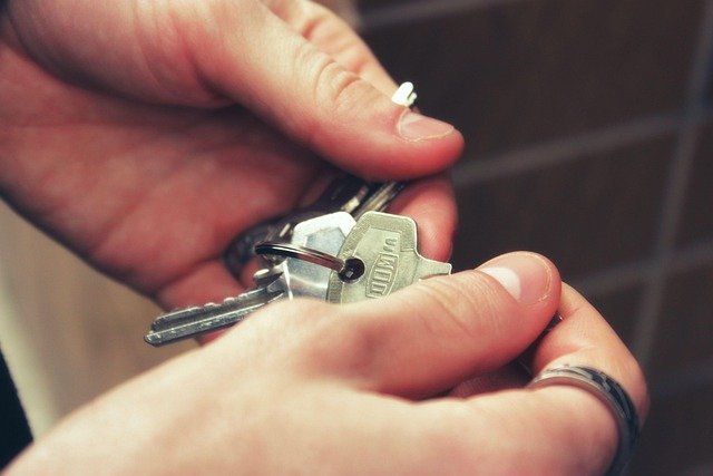 Hands holding house keys, a home that needs active coverage to avoid insurance mistakes