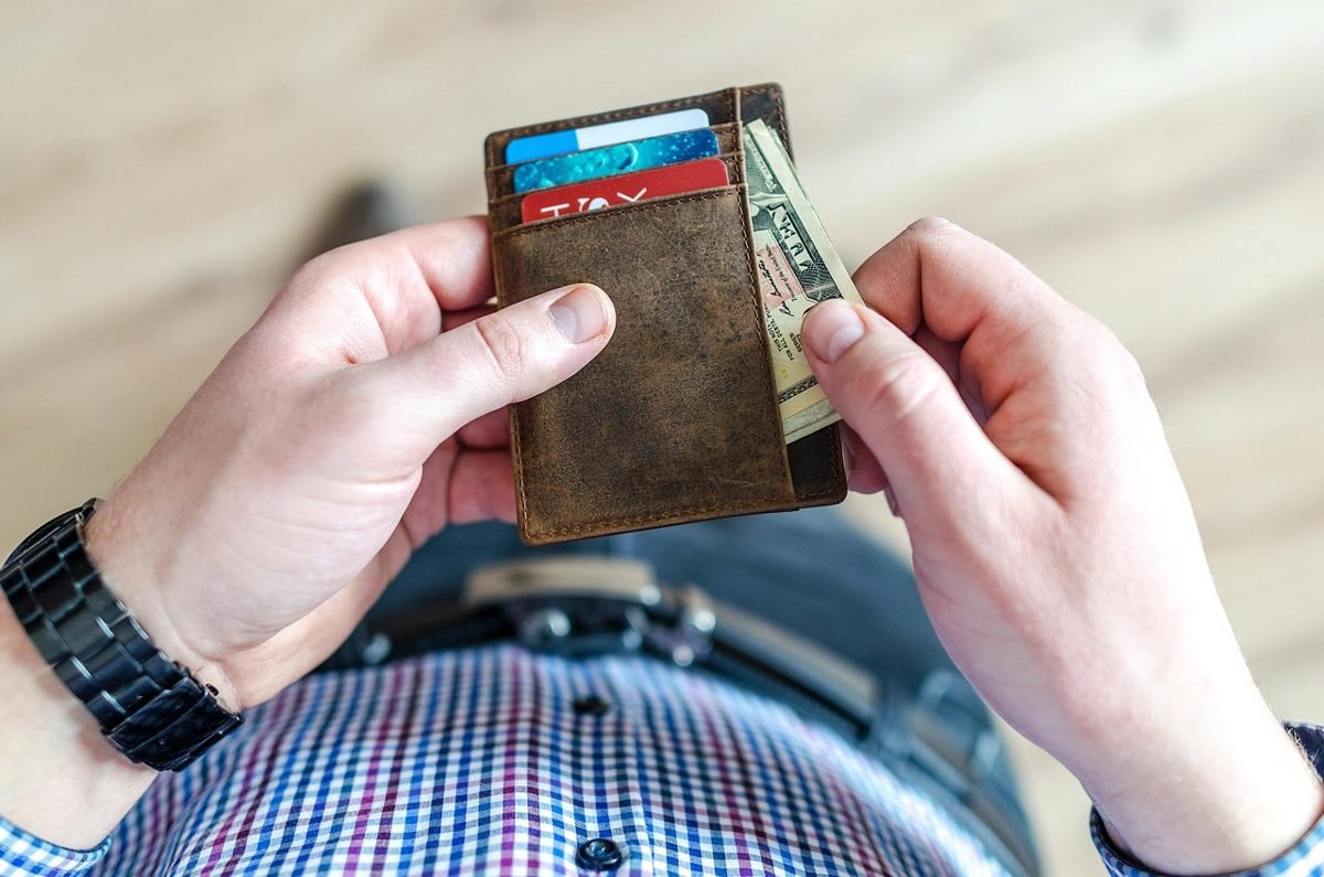 Hands holding a wallet while trying to save 1000 in 30 days