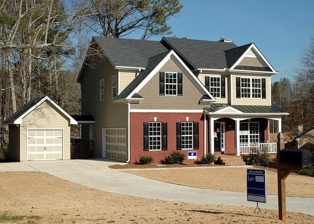 House with a for-sale sign, weighing private mortgage insurance against waiting to save 20 percent