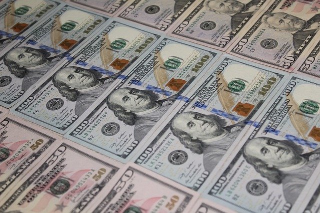 Dollar bills to set aside for taxes on a side hustle to full-time business