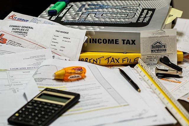 Income tax papers and a calculator, for comparing how treasury bills and I bonds are taxed