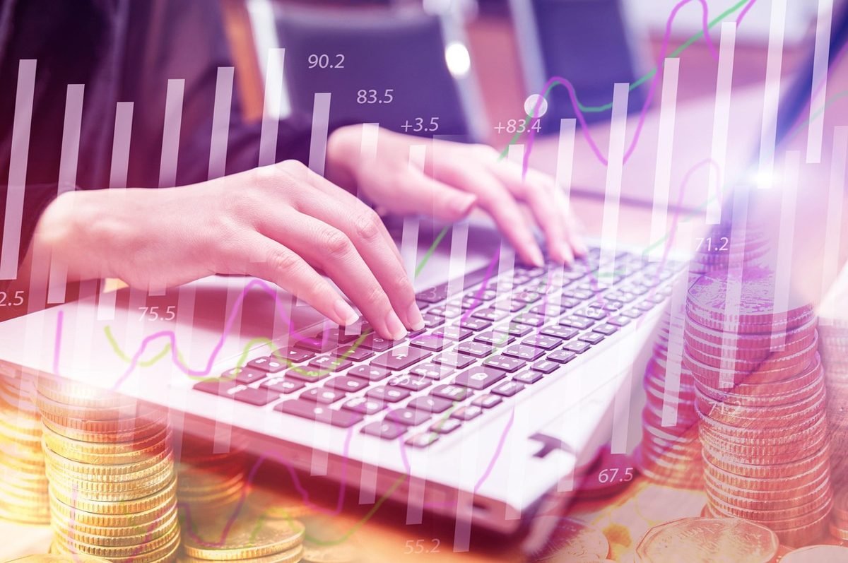 Laptop keyboard over coin stacks for a Roth IRA under 30