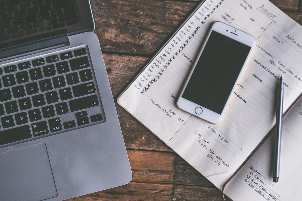 Laptop, phone and planner pages used as budget tools