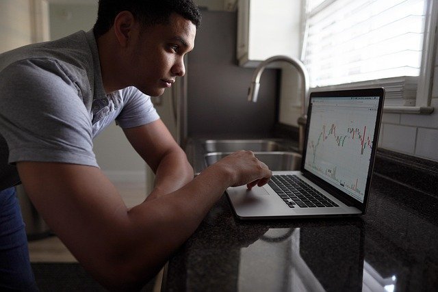 Man watching stock charts on a computer, one of the best investment apps for beginners to try first