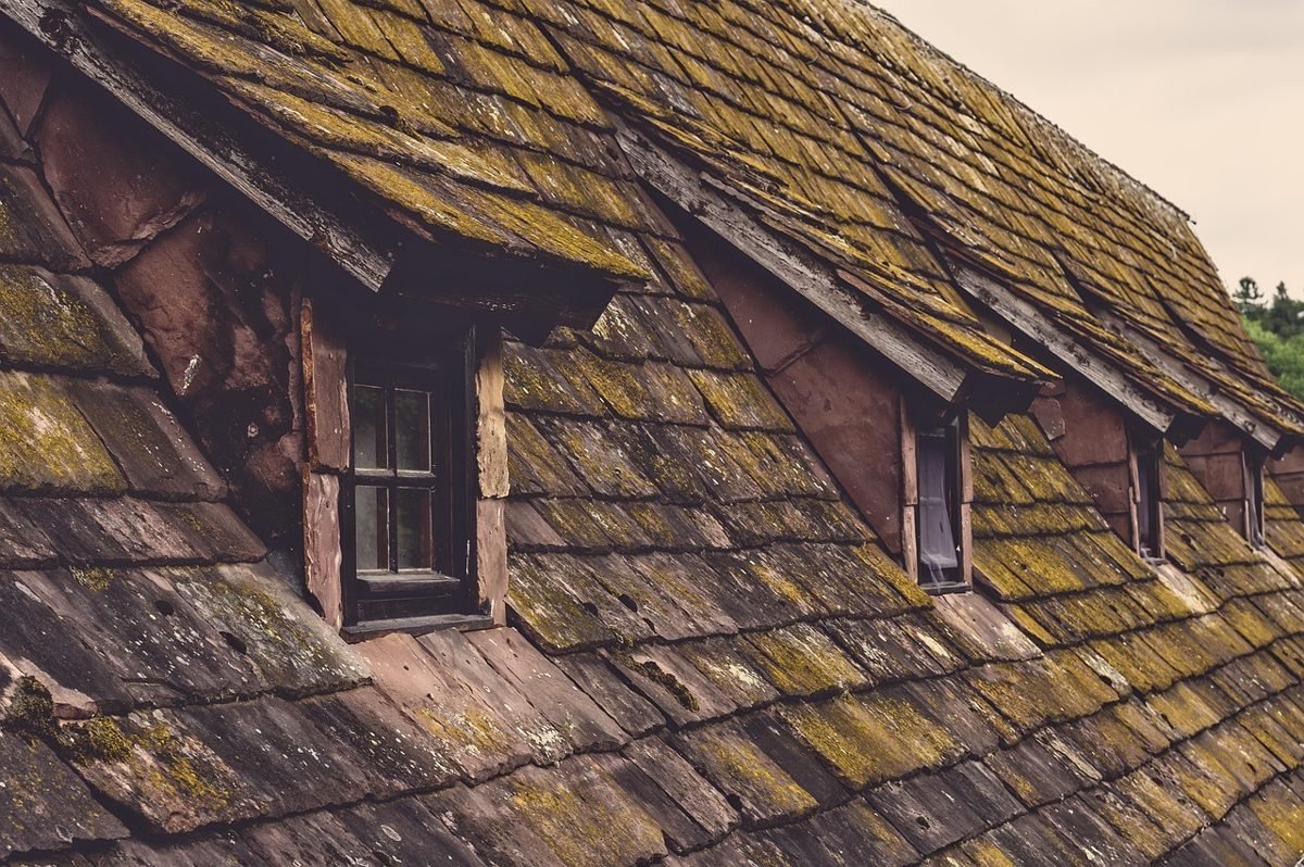Aging roof with dormers that a home inspection would check