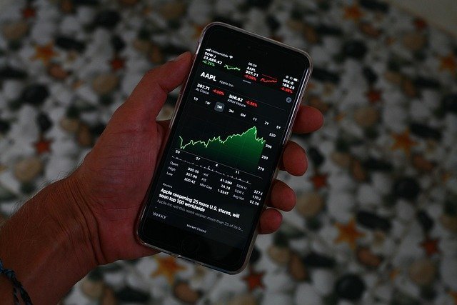 Phone showing a stock chart, the market path behind dollar-cost averaging vs lump sum