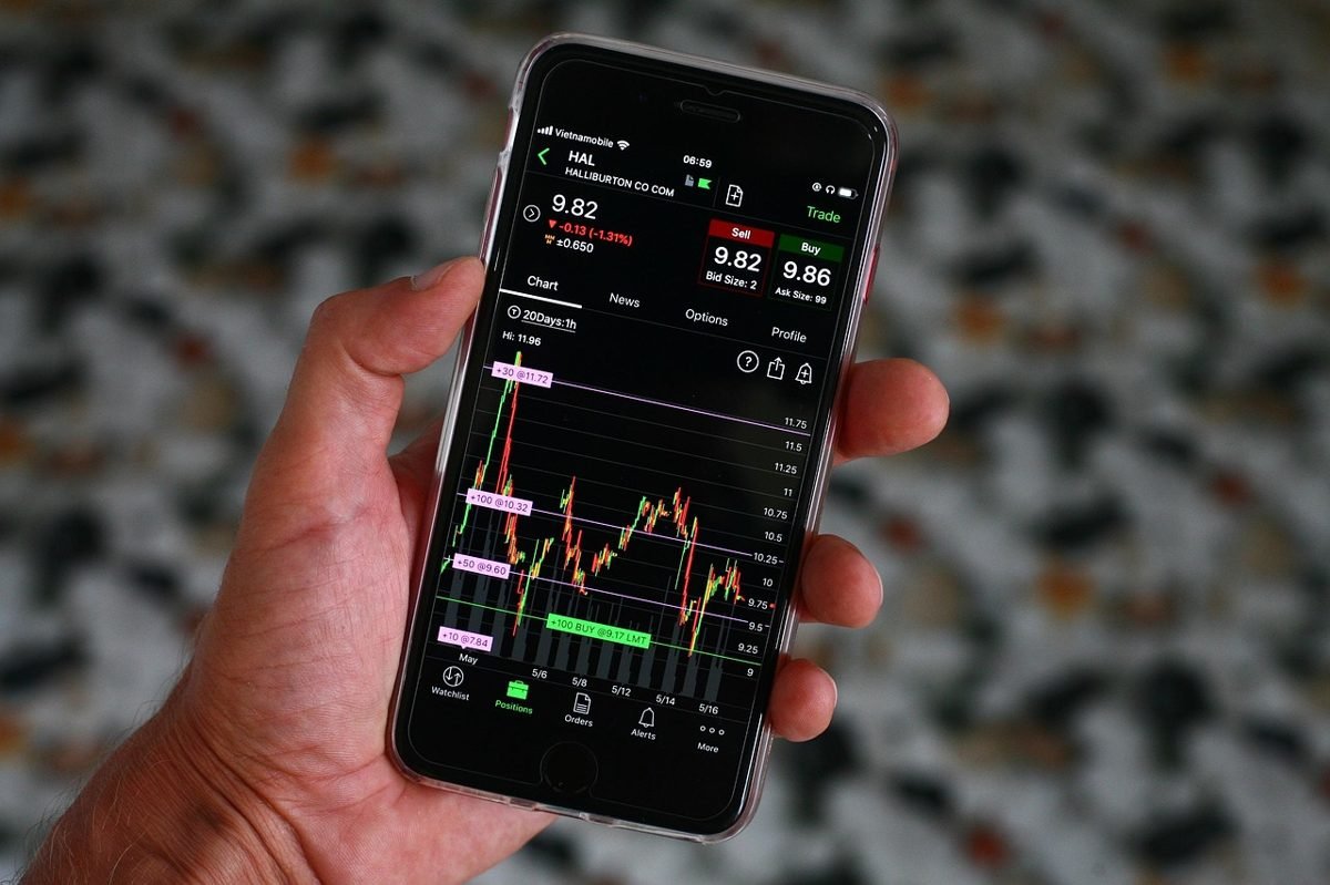 Phone showing a stock chart while investing with $100