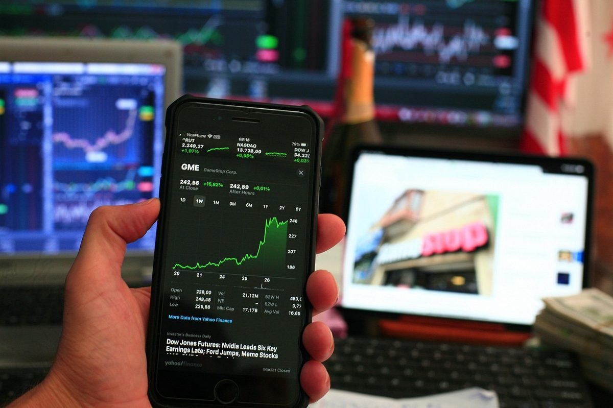 Phone showing an ETF price chart in the index funds vs ETFs debate