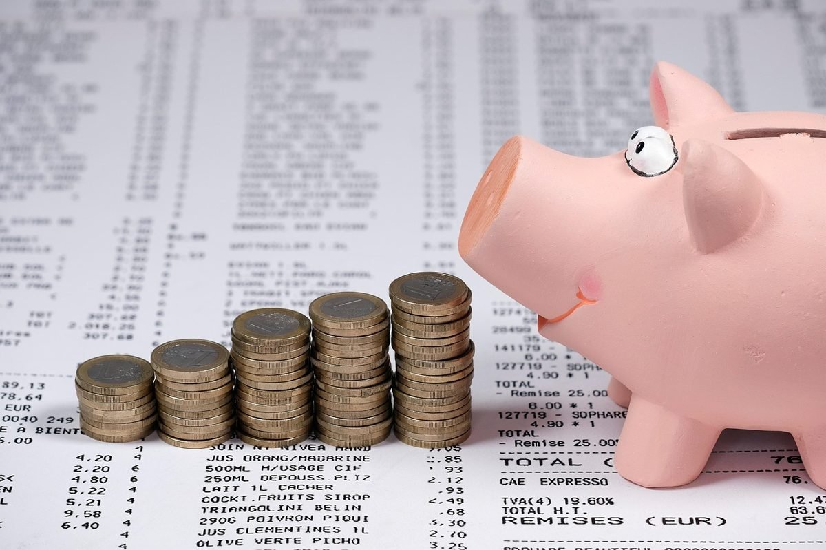 Piggy bank and coins to show fees in index funds vs ETFs