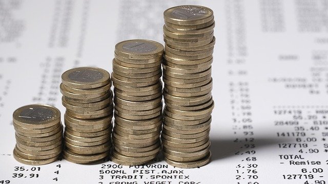Rising stacks of coins showing how a money market account earns interest over time