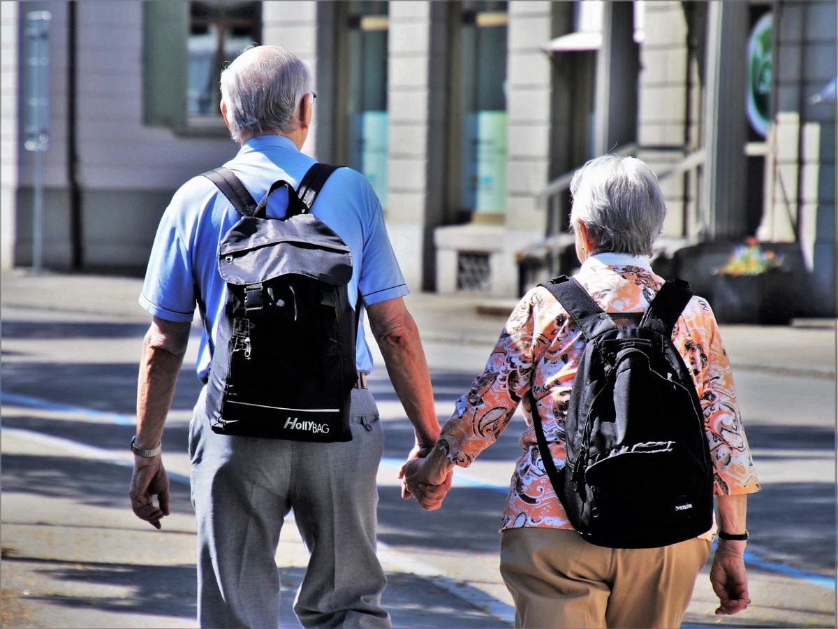 Senior couple walking, enjoying what deciding how much to save for retirement allows
