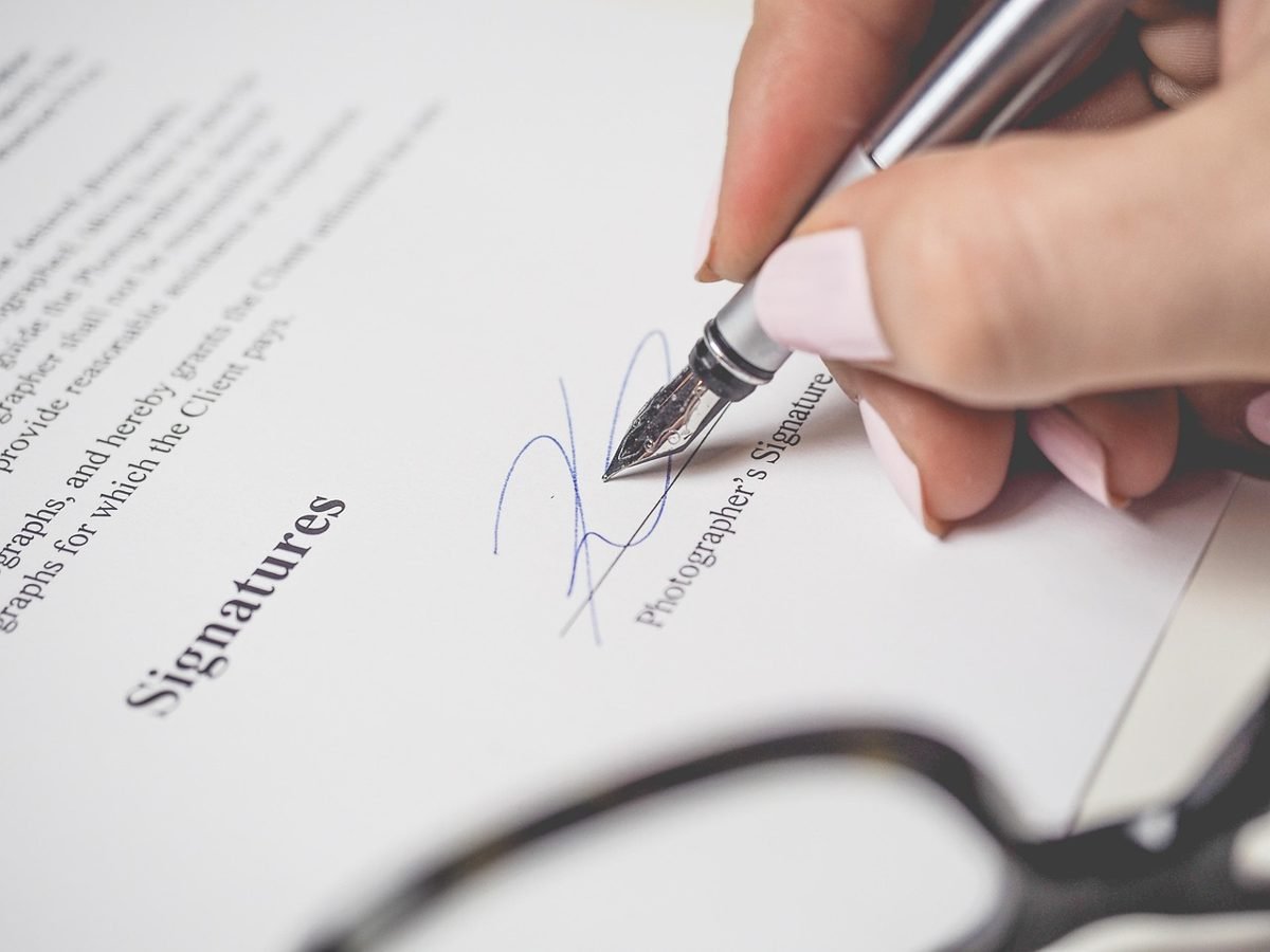 Hand signing the application for a life insurance policy