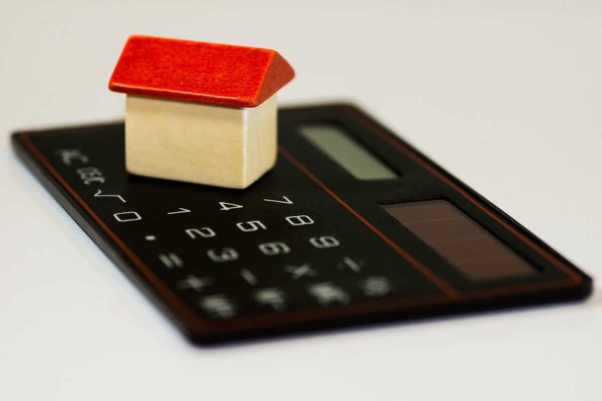 Small house model on a calculator to compare low down payment costs