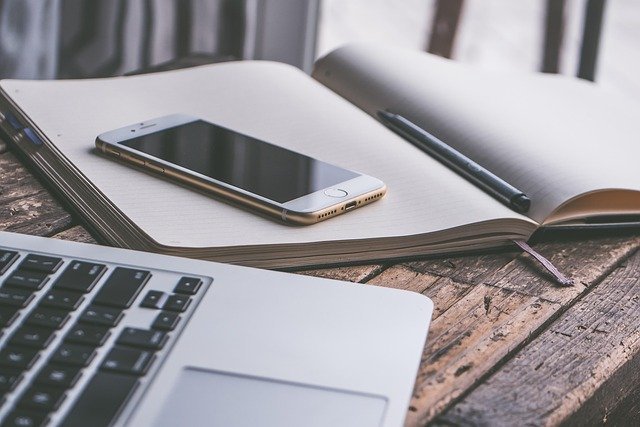 Smartphone and laptop on a desk, where beginners open an investing app