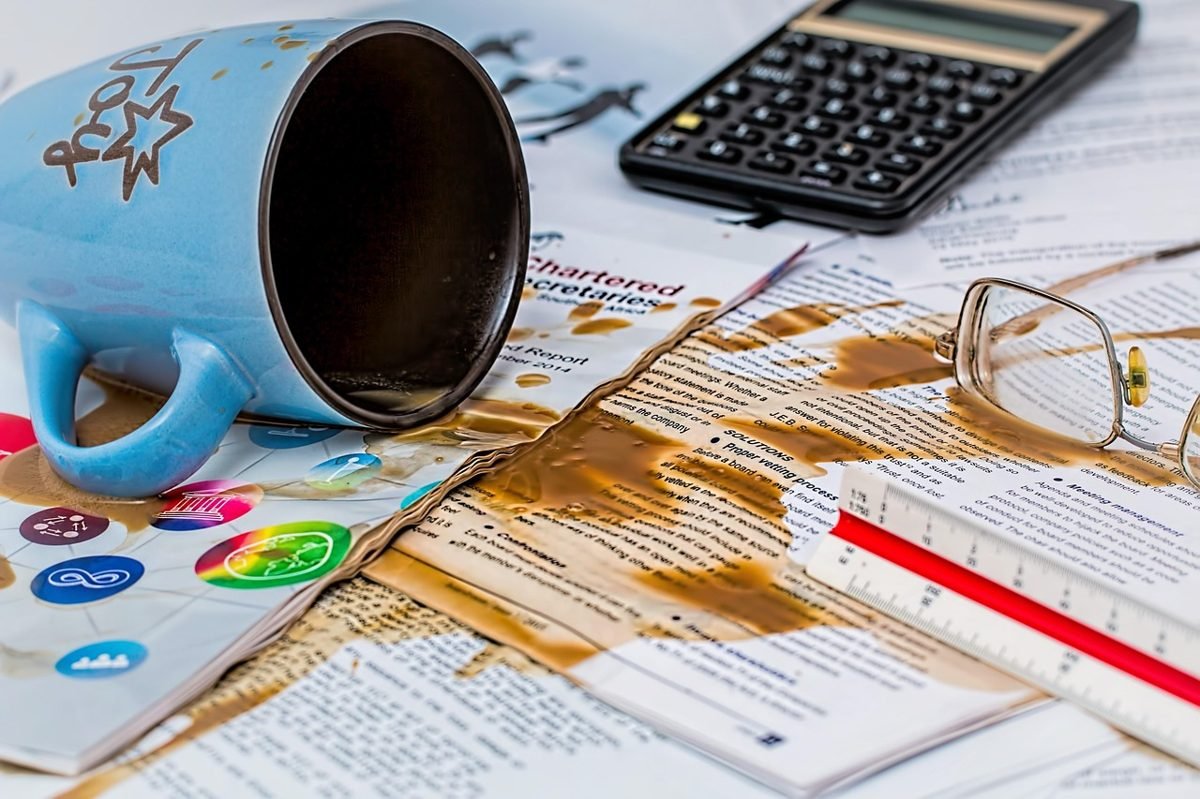 Spilled coffee on bills and a calculator, a budget mess when you are still broke