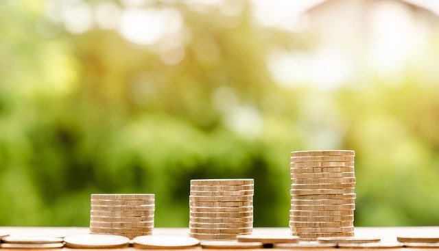 Three stacks of coins, goal buckets inside a savings account vs checking account plan