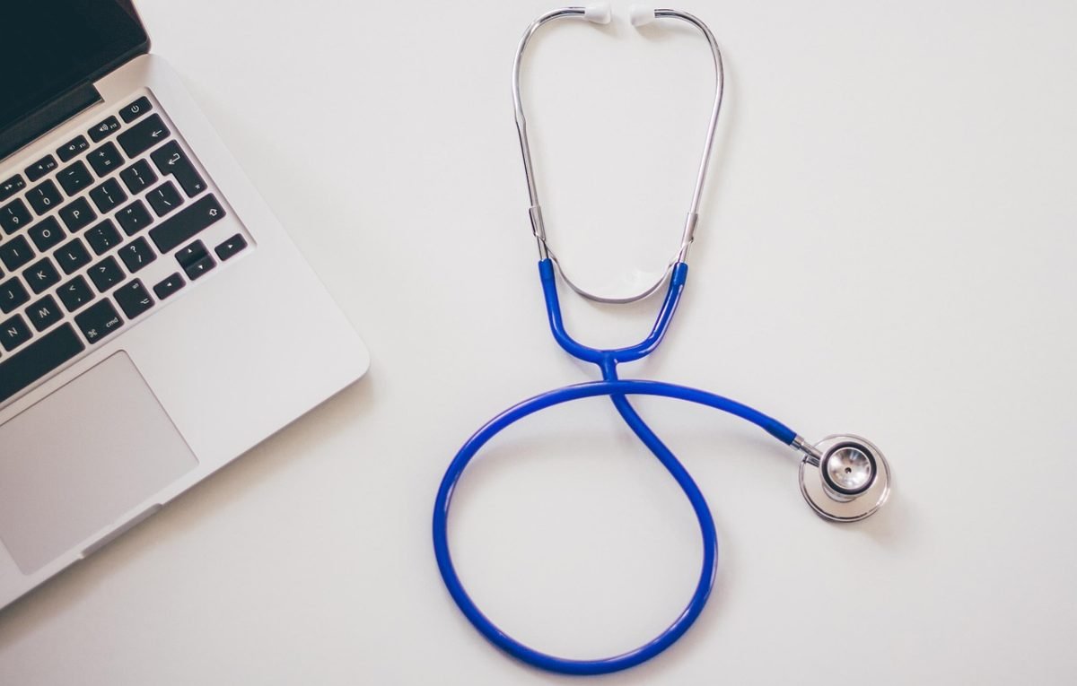 Stethoscope beside a laptop, choosing self-employed health insurance