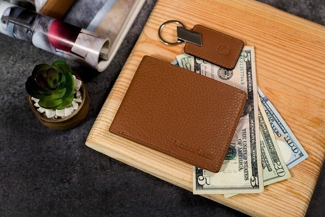 Wallet and bills on a wooden board before deciding whether to build a cd ladder