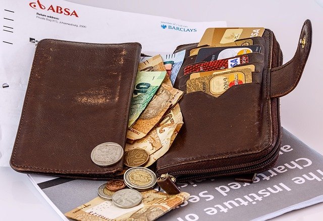 Wallet with cards and cash before splitting a paycheck in a savings account vs checking account setup