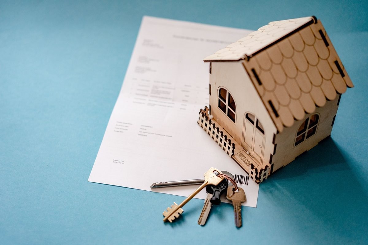 Wooden house model, keys and contract illustrating the rent vs buy decision